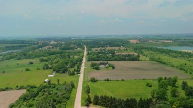 Countryside Fields 'ın geniş hava görüntüleri ve banliyö yolunun yanındaki çiftlik. Yüksek kalite 4k görüntü