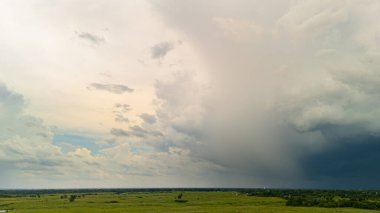 Yeşil topraklarda yağmur başlamadan önce fırtınalı bulutlarla dramatik bir siluet. Fırtınalı cennet, hava değişimi. Yüksek kalite fotoğraf