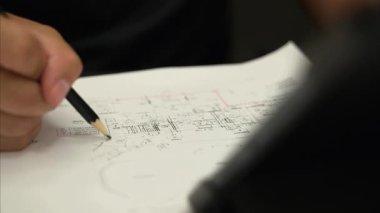 Architecture design project, architect designer engineer brainstorming and writing on interior drawing of building, floor plan, drafting printed on paper. High quality 4k footage