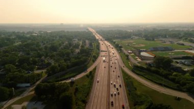 Highway road with the fast-moving traffic, trucks going to horizon and showing U.S. transportation infrastructure under the bright summer sky. Drone view. High quality 4k footage