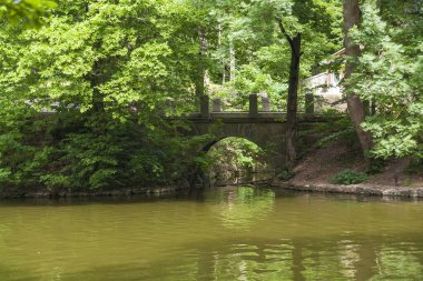 Uman, Ukrayna 'daki Sofievka botanik bahçesindeki bir göletin üzerindeki eski kemerli tuğla köprü.