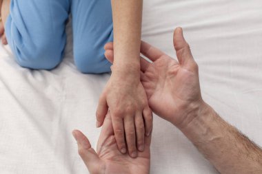 Çocuğun eli kırmızı noktalarla kaplı. Doktor çocuğun elini muayene eder. Rubella ya da atopik dermatit kavramı