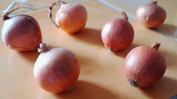 Mutfak masasına bir sürü arpacık soğanı bırakılmış. Yakın çekim..