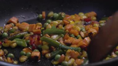 Donmuş sebzelerden oluşan bir karışım kızartma tavasında duruyor..