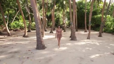 Mayolu Asyalı kadın, Maldivler 'deki tropikal adaya doğru sahile doğru gidiyor. Tatil ve seyahat kavramı