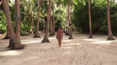 Mayolu Asyalı kadın, Maldivler 'deki tropikal adaya doğru sahile doğru gidiyor. Tatil ve seyahat kavramı