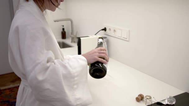 Νεαρή Γυναίκα Λινό Κιμονό Ανοίγει Ένα Μπουκάλι Prosecco Στην Κουζίνα — Αρχείο Βίντεο