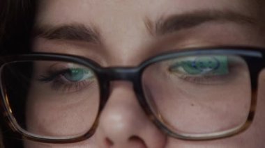 Borsa grafiklerinin broker gözlükleriyle ön plan çizelgesi olan gözlüklü kadın portresi. Büyük bir yatırım fonunda uluslararası ticaret ve aşırı çalışma kavramı