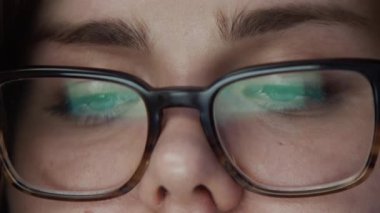 Borsa grafiklerinin broker gözlükleriyle ön plan çizelgesi olan gözlüklü kadın portresi. Büyük bir yatırım fonunda uluslararası ticaret ve aşırı çalışma kavramı