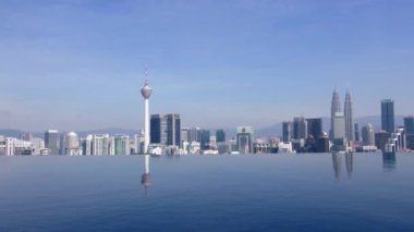 Kuala Lumpur 'un sonsuz yüzme havuzu üzerindeki panoramik manzarası. Şehir, Malezya 'nın kültürel, mali ve ekonomik merkezi olarak hizmet vermektedir. Gündüz KL silueti. 4k HiRes çekim yapıyor..