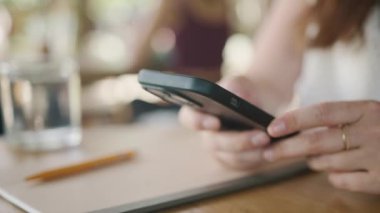 İnternet 'e göz atmak için akıllı telefon kullanan, kafede masada otururken okuyup mesajlaşan serbest çalışan bir kadın. Yaşam tarzı, kahve dükkanında çalışmak. Sosyal medya.