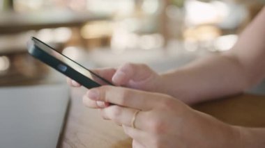 İnternet 'e göz atmak için akıllı telefon kullanan, kafede masada otururken okuyup mesajlaşan serbest çalışan bir kadın. Yaşam tarzı, kahve dükkanında çalışmak. Sosyal medya.