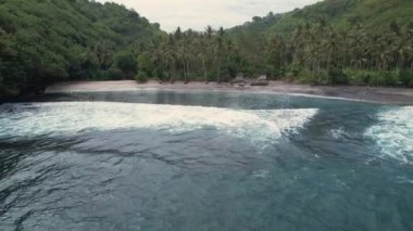 Tropikal plajın havadan kuşbakışı görüntüsü ve çöp kalçası. Hint Okyanusu kıyısında. Gündüz vakti doğa ve seyahat. Güzel doğal yaz tatili seyahati. Karaya doğru uç. Temizlik kavramı