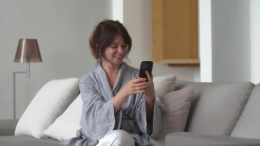 Mutlu güzel kadın vlogger 'ı elinde akıllı telefonla kameraya konuşuyor video bloğu çekiyor, evde video görüşmesi yapıyor ve sanal mobil görüntülü sohbet uygulaması ile konuşuyor. Webcam görüntüsü. Yüksek kalite 4k görüntü