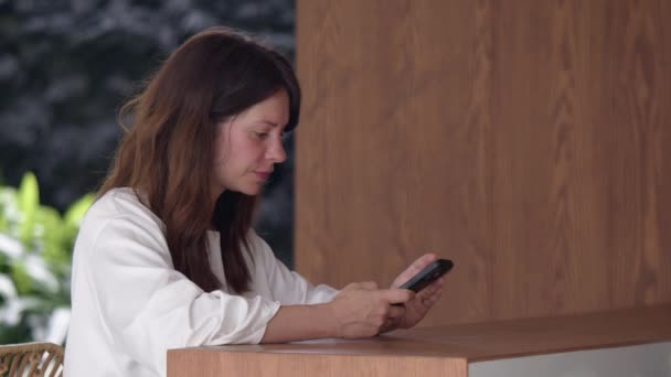 Uśmiechnięta Kobieta Białej Koszuli Korzystająca Telefonu Widok Boku Siedząca Przy — Wideo stockowe