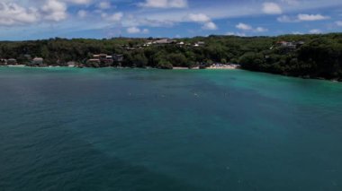 Bali 'deki Padang Padang plajı tatil köyleri ve turkuaz okyanusla. Üst hava görüntüsü, kamera yüksek kalitede 4K görüntü alıyor.