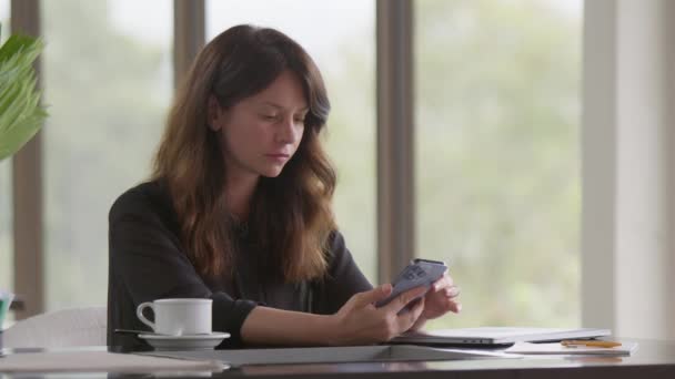 Piękna Kobieta Korzystająca Telefonu Siedząca Przytulnym Domu Lub Wnętrzu Kawiarni — Wideo stockowe