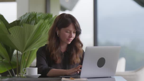 Zakenvrouw Oordopjes Typen Laptop Computer Gezellig Appartement Cafe Interieur Panoramisch — Stockvideo