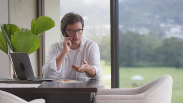 Businessman Gesturing Talking Phone Emotional Conversation Sitting Table Laptop Panoramic — Stock Video