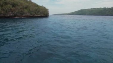 Nusa Penida Adası 'nın hava aracı kuş bakışı görüntüsü. Hint Okyanusu kıyısında. Gündüz vakti doğa ve seyahat. Tatil seyahati kavramı. İleri uç.