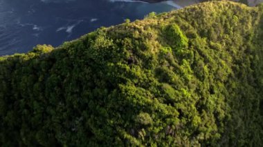 Uçurumla kayalık kumsalın kuş bakışı görüntüsü. Hint Okyanusu kıyısında. Gün batımında doğa ve yolculuk. Güzel doğal yaz tatili seyahat konsepti. Nusa Penida Adası.