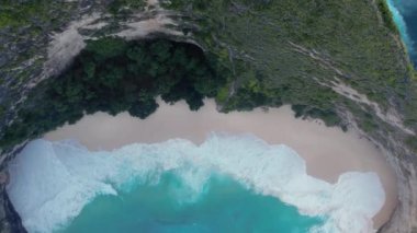 Uçurumla kayalık kumsalın kuş bakışı görüntüsü. Hint Okyanusu kıyısında. Gündüz vakti doğa ve seyahat. Güzel Nusa Penida, yaz tatili konsepti. Üst görünüm.