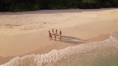 Bir grup profesyonel dansçı gün batımında Maldivian plajında prova yapıyorlar. Hava aracı üstgeçitten ateş etti. Yüksek kalite 4K görüntü. Yüksek kalite 4k görüntü.