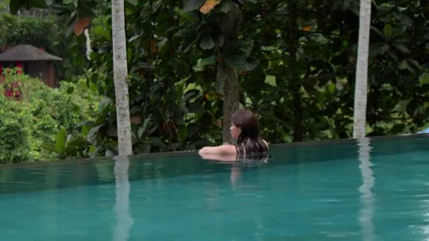 Aantrekkelijke Vrouw Rustend Aan Rand Van Overloopzwembad Regen Tropisch Bos — Stockvideo