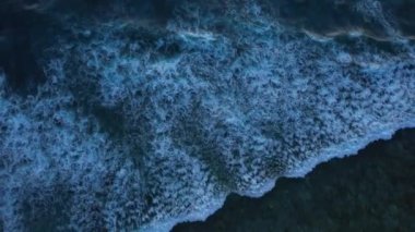 Düşen okyanus dalgalarının yukarıdan aşağıya doğru olan görüntüsü, insansız hava aracı derin suyun üzerinde yavaşça havada süzülüyor. Gili Trawangan Adası, Lombok. Yüksek kalite 4k görüntü