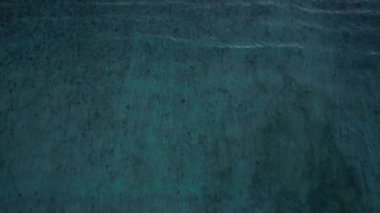 Düşen okyanus dalgalarının yukarıdan aşağıya doğru olan görüntüsü, insansız hava aracı derin suyun üzerinde yavaşça havada süzülüyor. Gili Trawangan Adası, Lombok. Yüksek kalite 4k görüntü