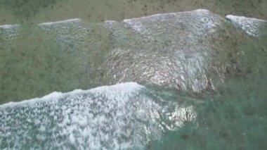 Gökyüzü deniz suyuyla güzel kumsal manzarası, dalga geçişleri, İHA kamerasından havadan çekilen görüntüler. Yüksek kalite 4k görüntü
