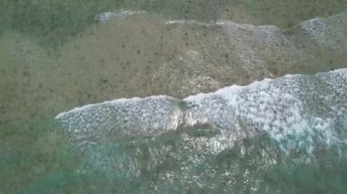 Gökyüzü deniz suyuyla güzel kumsal manzarası, dalga geçişleri, İHA kamerasından havadan çekilen görüntüler. Yüksek kalite 4k görüntü