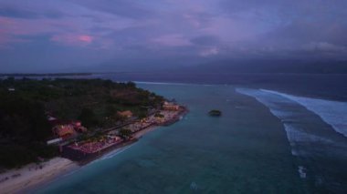 Gili Trawangan 'ın akşamüstü hava görüntüsü, Bali, Endonezya. Barlar ve restoranlar, insanlar deniz kıyısında takılıyor. Yüksek kalite 4k görüntü