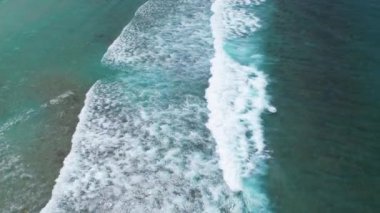 Gökyüzü deniz suyuyla güzel kumsal manzarası, dalga geçişleri, İHA kamerasından havadan çekilen görüntüler. Yüksek kalite 4k görüntü