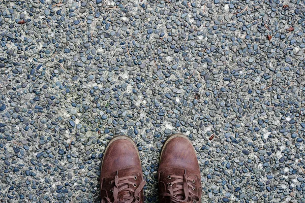 舗装された石の歩道に茶色のハイキングブーツのペアのトップビューのイメージ — ストック写真