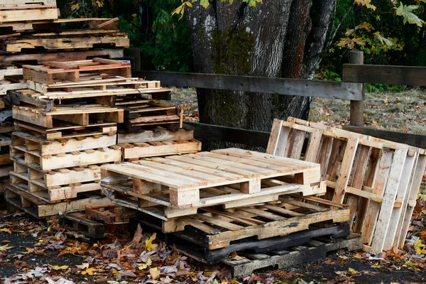 An image of loosely stacked wooden pallets used for shipping and receiving.