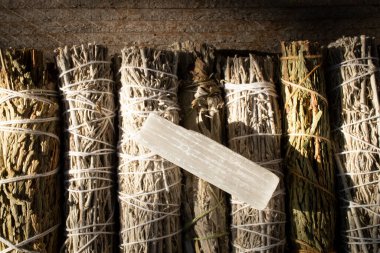 A top view image of several healing smudge sticks and small selenite crystal.  clipart