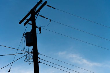 Bir güç transformatörü ve elektrik hatlarının silüeti.. 