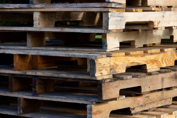 An abstract image of several old and dirty wooden pallets stacked and waiting for recycling.