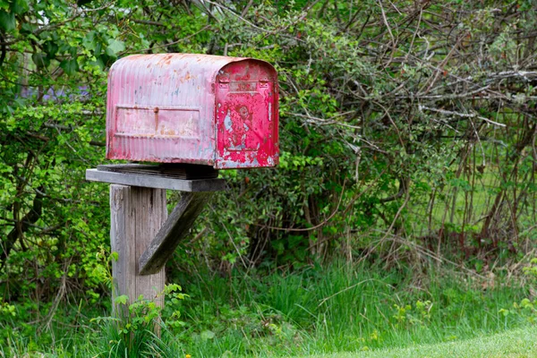Ahşap Bir Çit Direğindeki Solmuş Soyulan Kırmızı Boyalı Paslı Posta — Stok fotoğraf