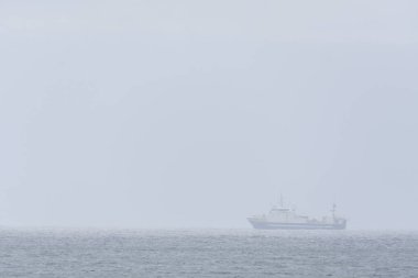 Vancouver Adası açıklarındaki sis gibi kalın bir sis yüzünden zar zor görünen büyük bir balıkçı teknesinin görüntüsü.. 