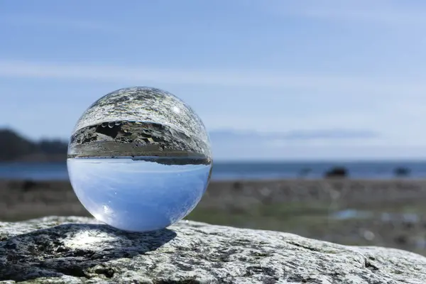 岩の上に安らぎ 岩の海岸線と太平洋のイメージを反映した写真レンズボールのイメージ ロイヤリティフリーのストック画像