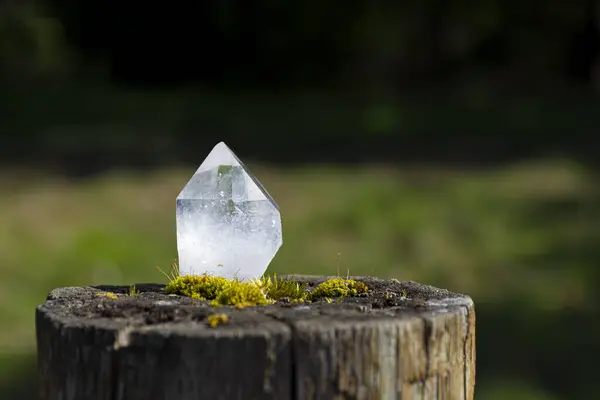 モスで覆われた塀のポストに休む透明な水晶のイメージ ストック写真
