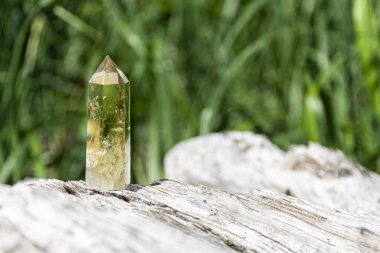 Çatırdayan ağaç kütüğünün üzerinde duran çatırdayan bir kristal kule görüntüsü..