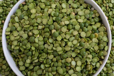 Kurumuş yeşil bezelyelerden oluşan akışkan bir kasenin üst görüntüsü.. 