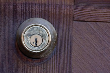 Ahşap bir kapıya kilitlenmiş eski ve pis bir güvenlik kapısı görüntüsü.. 