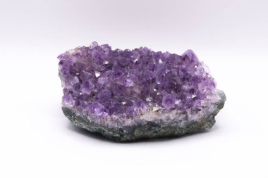 Parlak beyaz bir arka planda büyük parlak bir ametist kristal jeotunun görüntüsü..