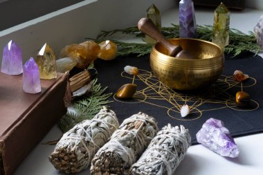 Şifalı kristaller ve adaçayı lekeleriyle kristal bir ızgarada şarkı söyleyen pirinç meditasyon kasesinin yakın plan görüntüsü.. 