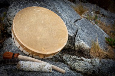 Leather meditation drum with white sage smudge stick and leather rattle. clipart