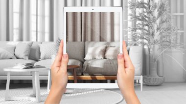Hands holding tablet showing living room in farmhouse style, total blank project background, augmented reality concept, application to simulate furniture and interior design products